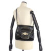 1970s Gucci saddle bag in black leather with muted gold hardware, an expandable bottom, wide shoulder strap, and burgundy leather lining | Luna Bags - Image 4
